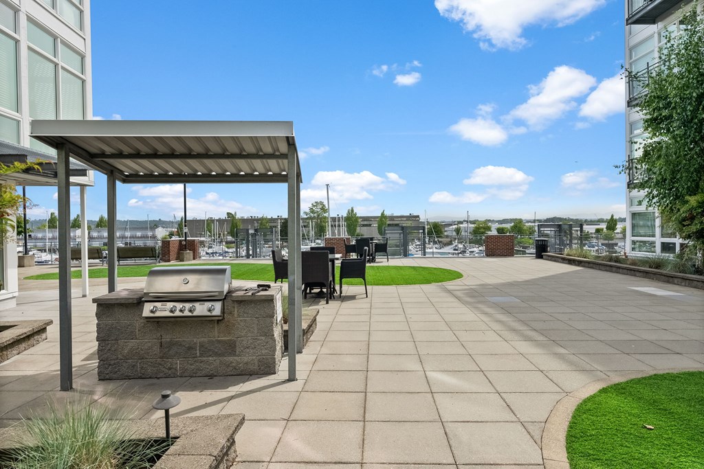 A patio area with a grill and seating area.