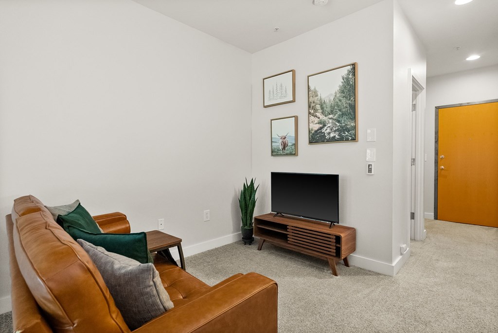 A living room with a brown couch and a fireplace.
