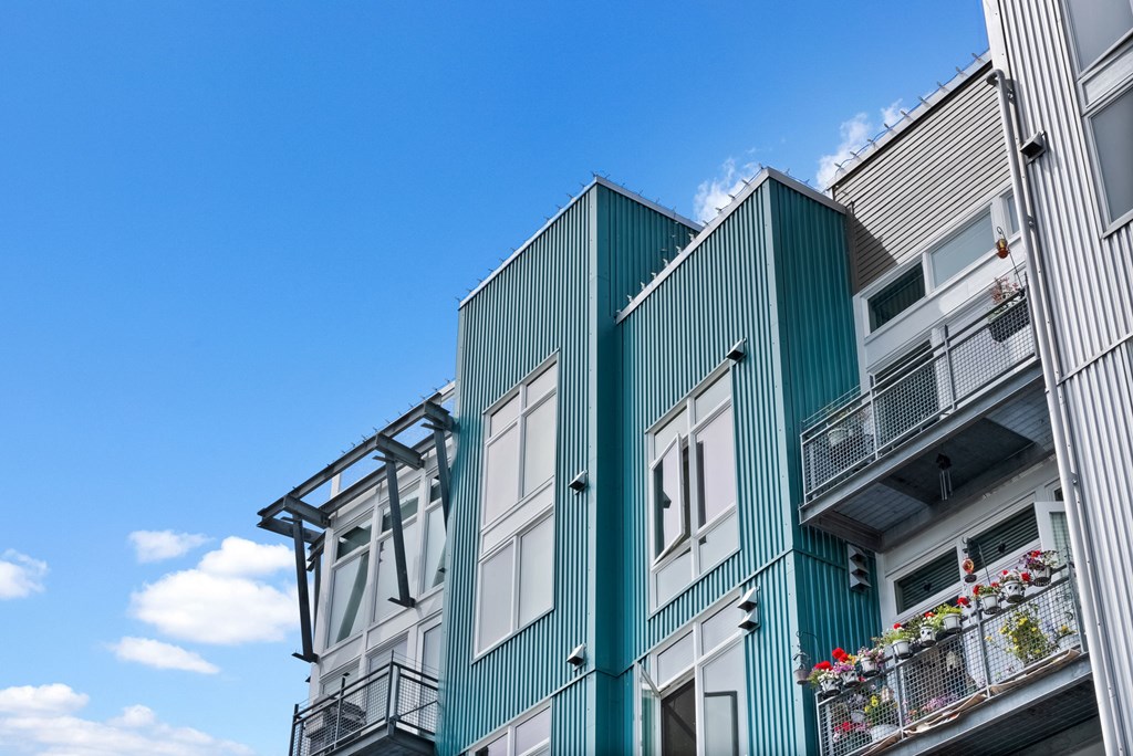 A modern building with balconies and flower pots.