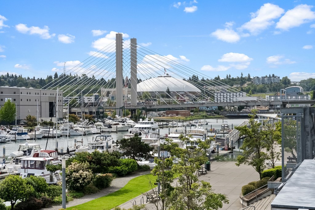 A bridge over a marina with boats and a building in the background.