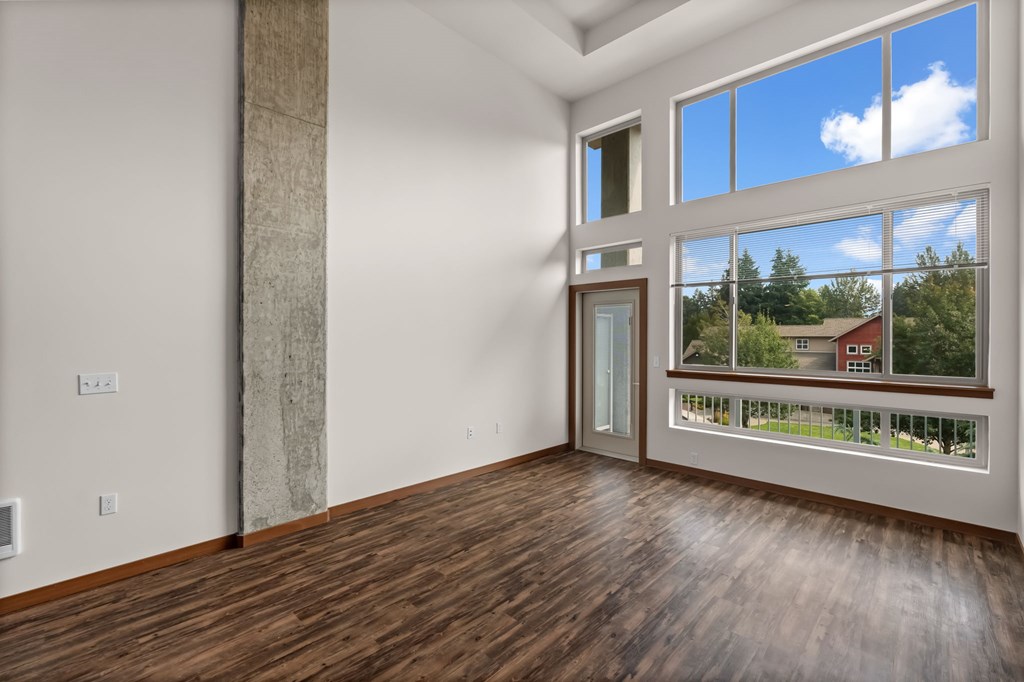 A room with a large window and a wooden floor.