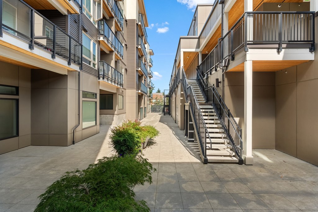 A long hallway with stairs and plants on the side.