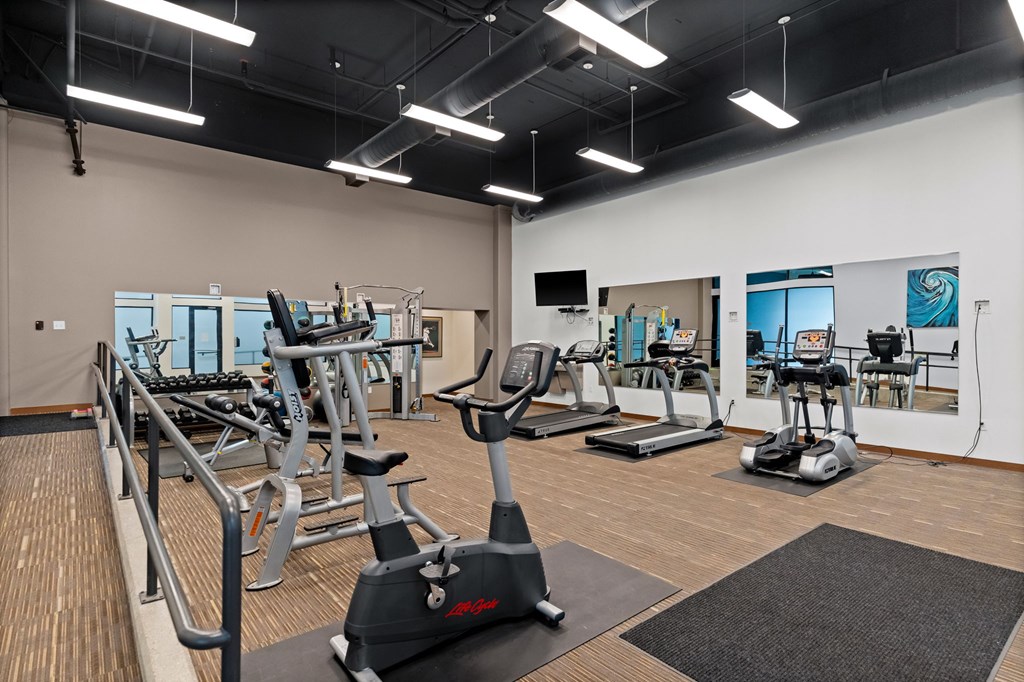 A gym with treadmills, elliptical machines, and other exercise equipment.