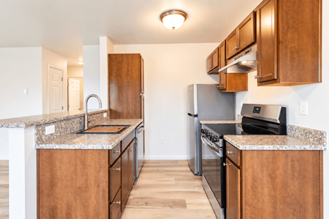A kitchen with wooden cabinets and granite countertops.