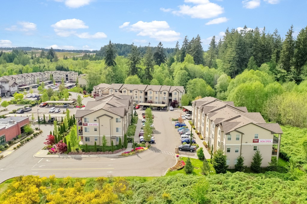 an aerial view of a building complex with trees in the background