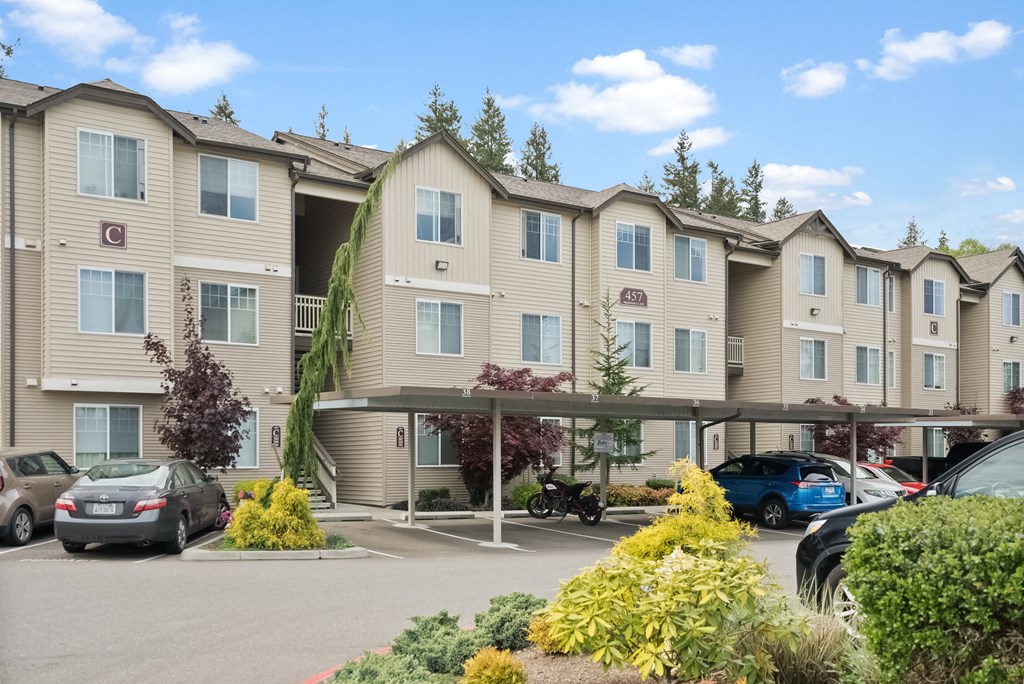 an apartment building with cars parked in a parking lot