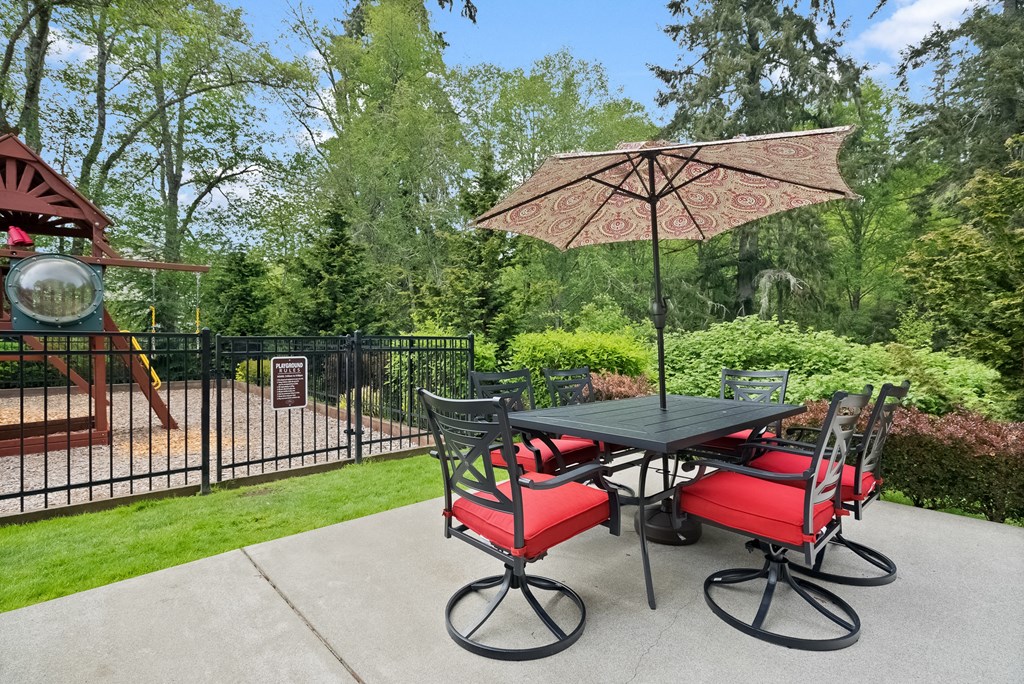 a patio with a table and chairs and an umbrella