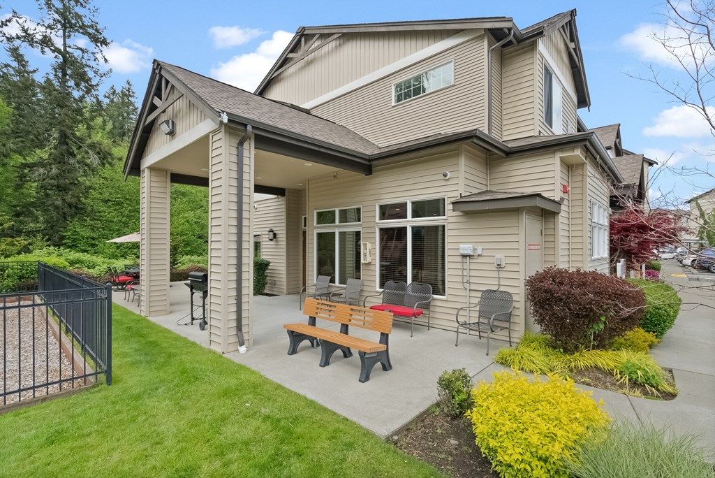 the back patio of a house with a picnic table and chairs