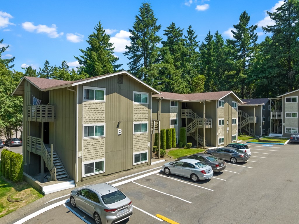 an apartment building with cars parked in a parking lot