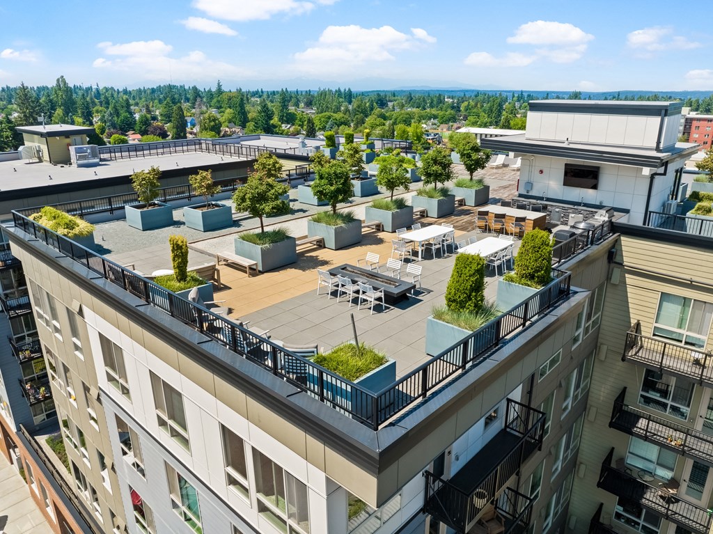 an aerial view of an apartment building with a rooftop patio and trees