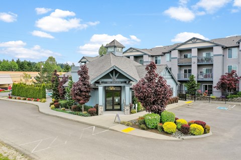 the view of the front of a building with a parking lot and landscaping