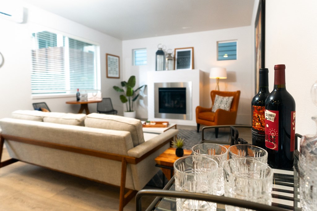 a living room with a couch and a table with glasses and bottles of wine