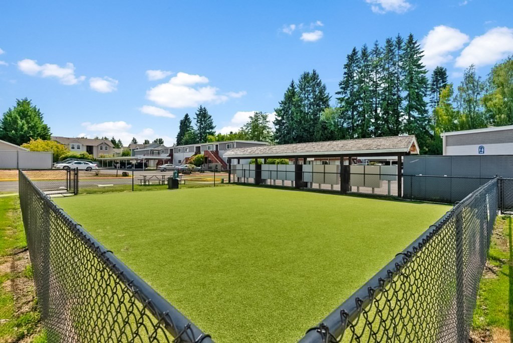 a baseball field in front of a building with a chain link fence