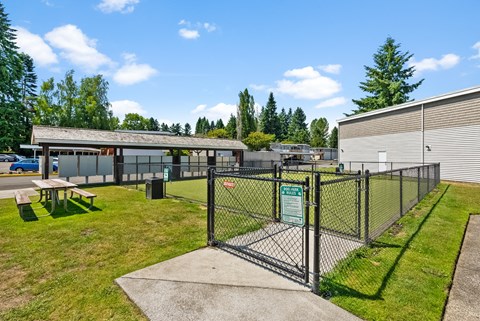 a fenced in area with a picnic table in front of a building