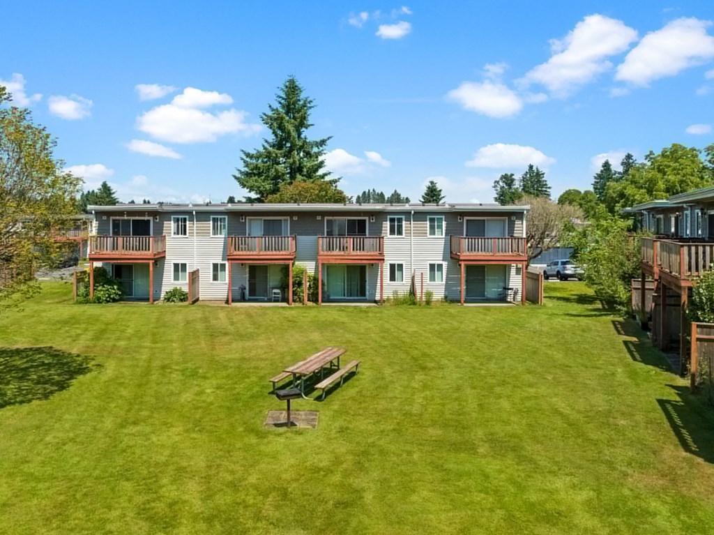 a backyard with a picnic table in front of a building