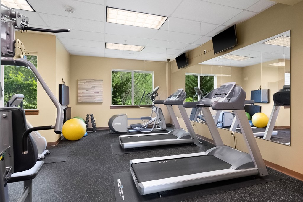 two treadmills and other exercise equipment in the gym at the community center