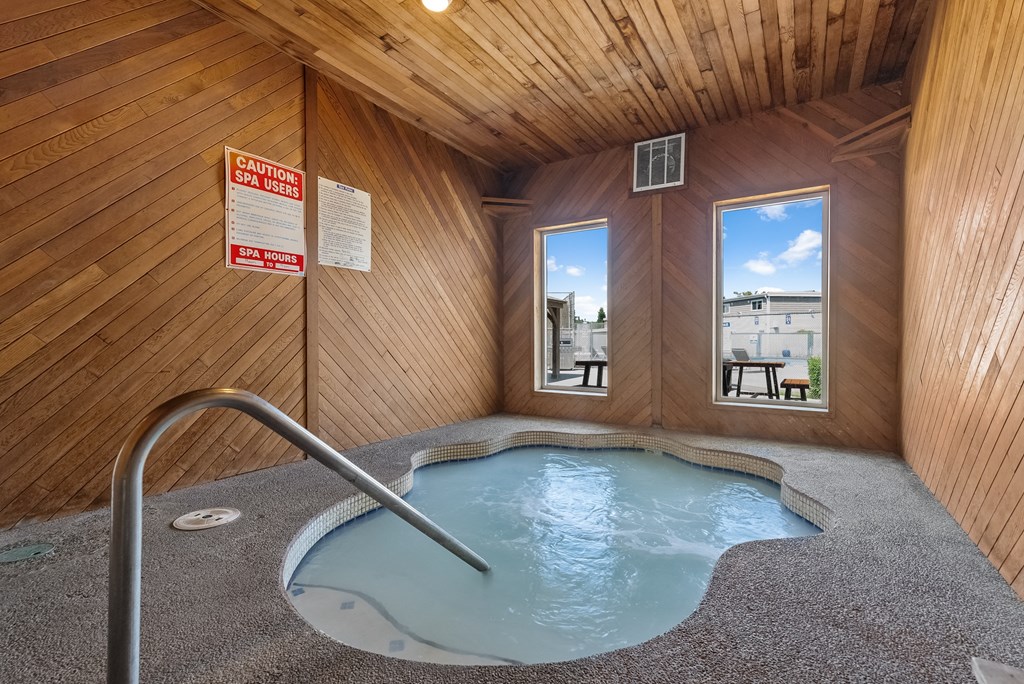 a hot tub in a cabin with wood walls and a window