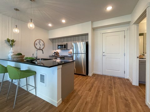a kitchen with a island and a stainless steel refrigerator