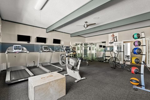a gym with treadmills and weights and a table