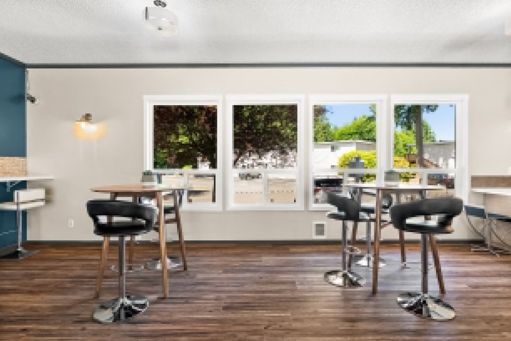 a common area with tables and chairs and windows