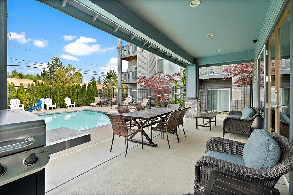 a patio with a pool and chairs and a table
