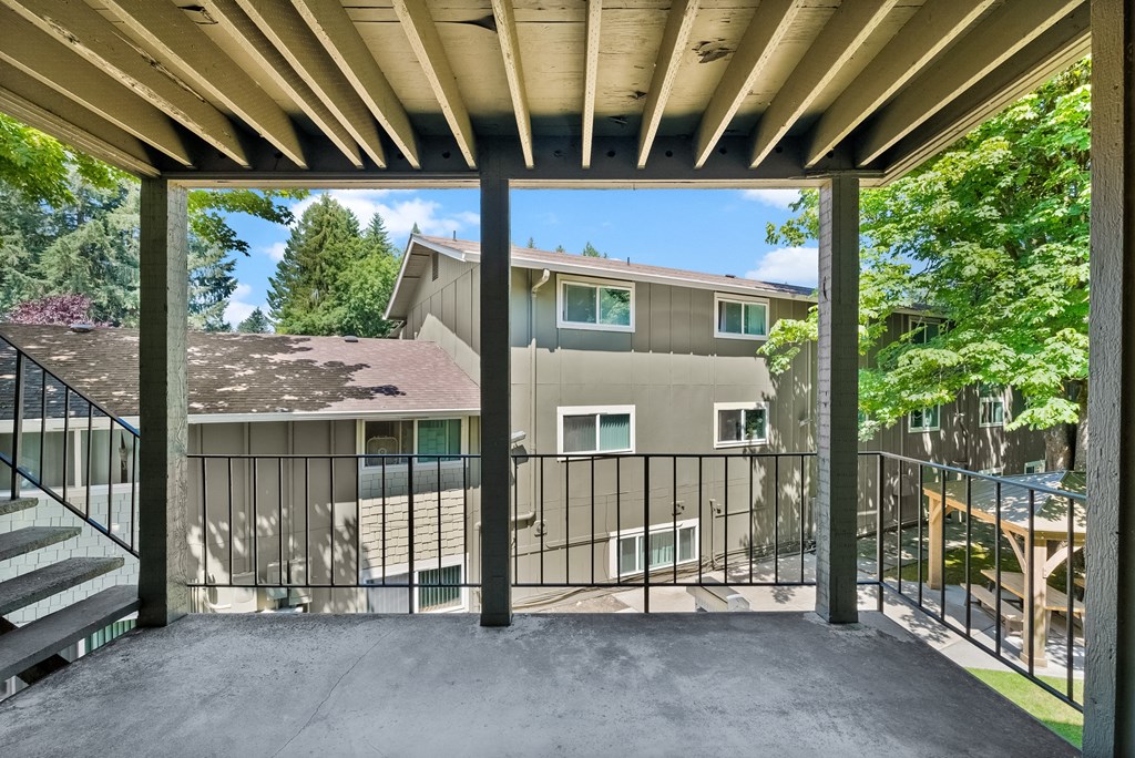 the view of a house from a balcony with a black railing