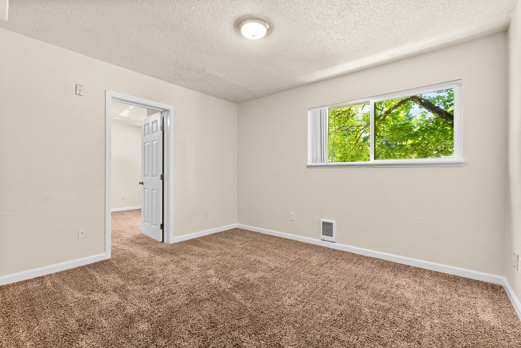 an empty room with carpet and a window