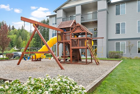 a swing set in front of an apartment building