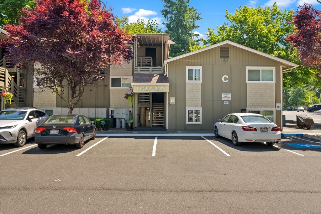 a parking lot with cars in front of an apartment building