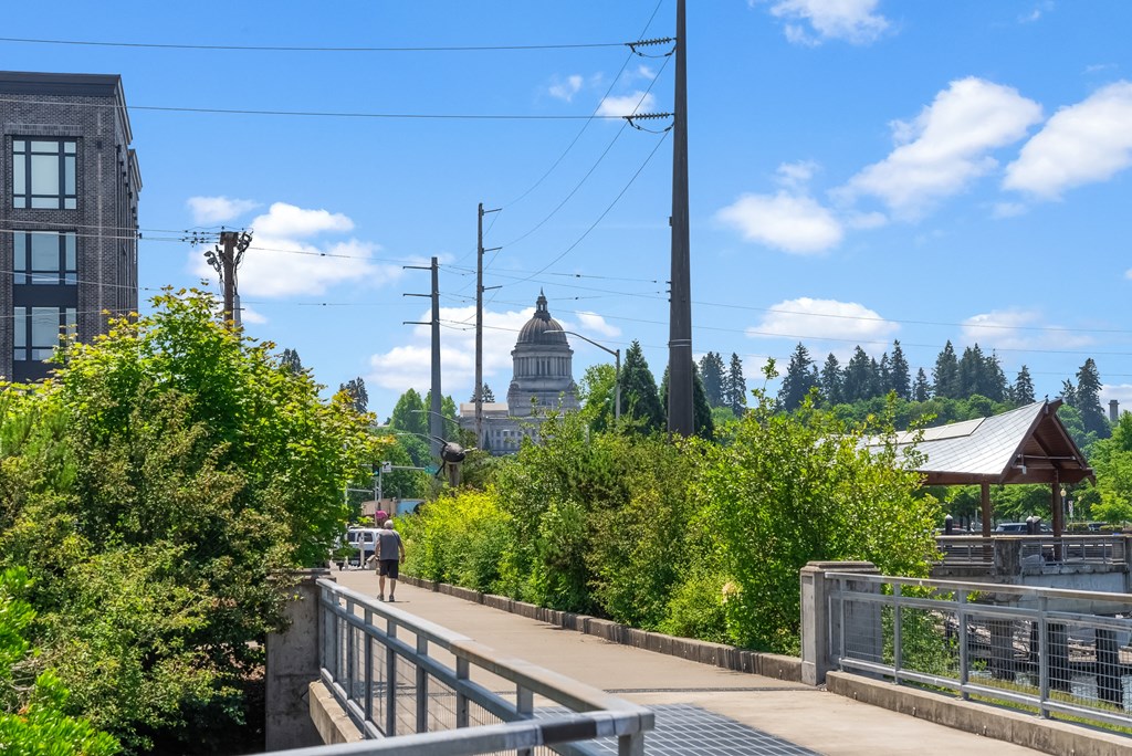 a man walking on a bridge with a view of the city
