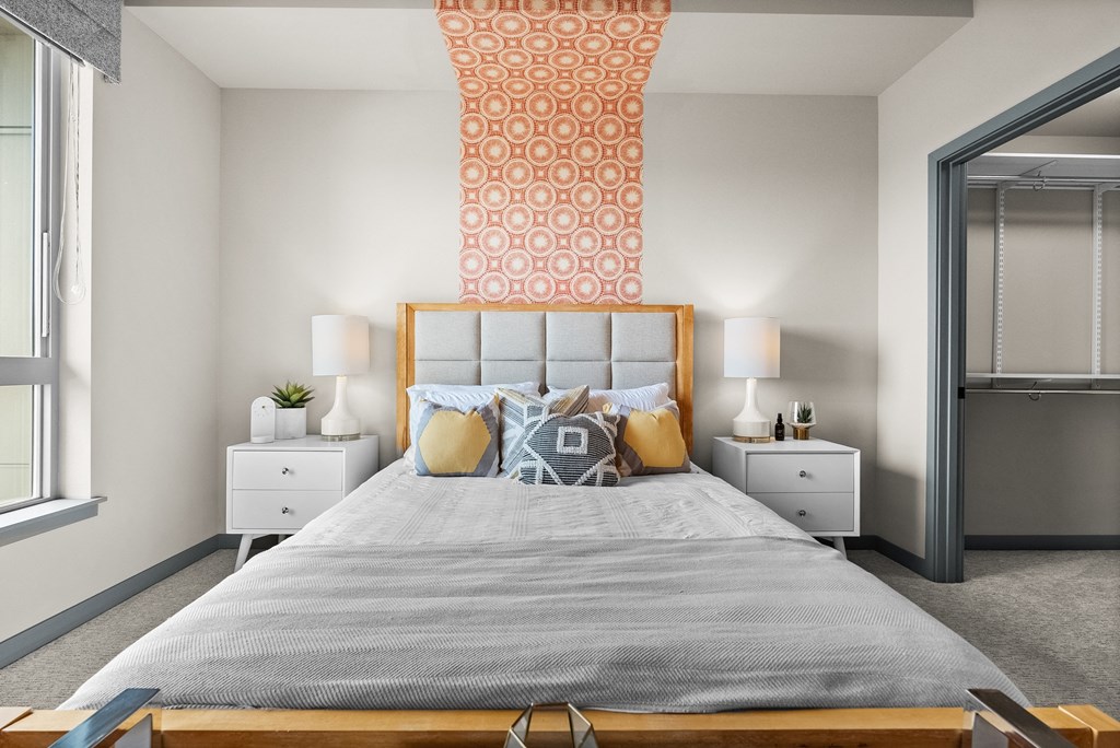 a bedroom with a bed and a geometric wallpaper on the wall