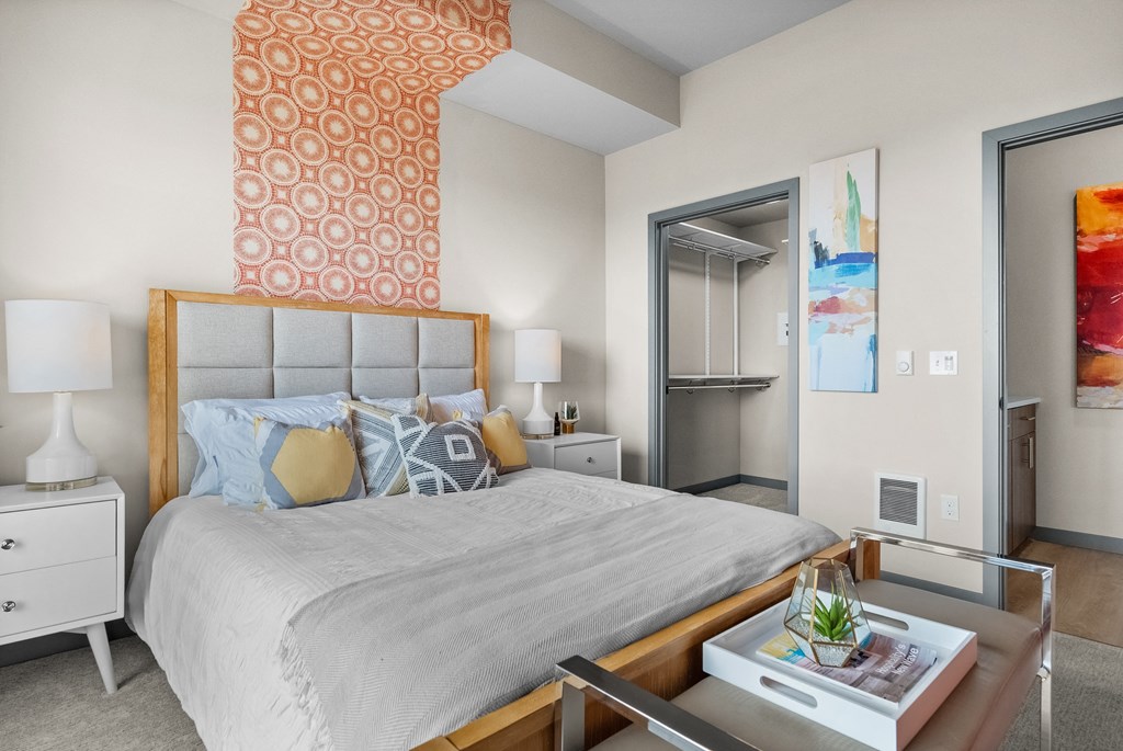 a bedroom with a large bed and a mirrored closet