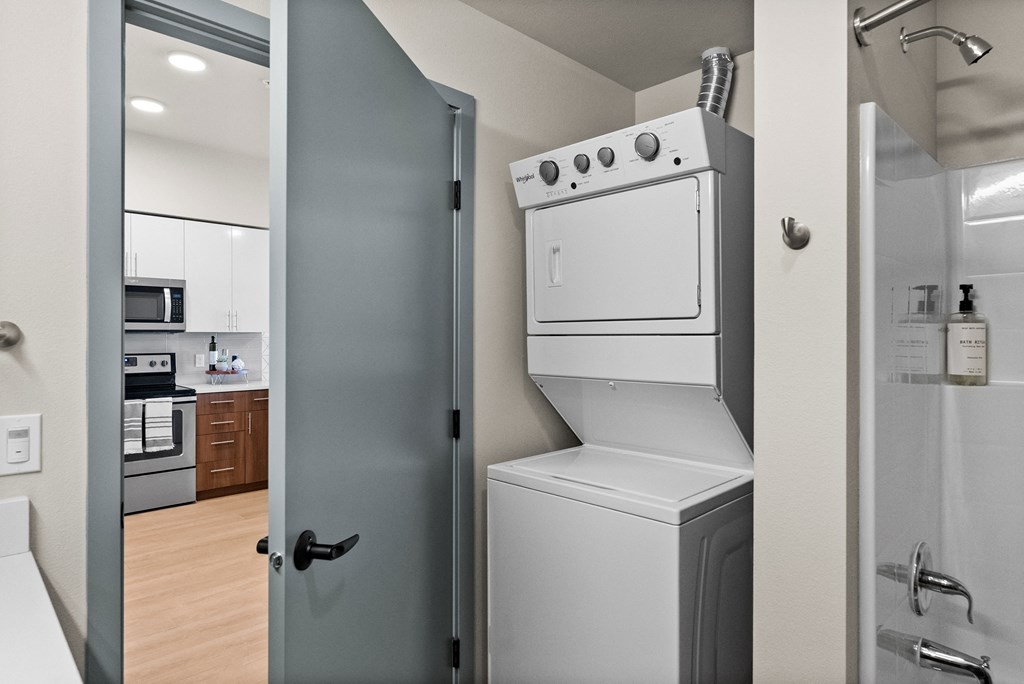a laundry room with a washer and dryer and a door to a kitchen