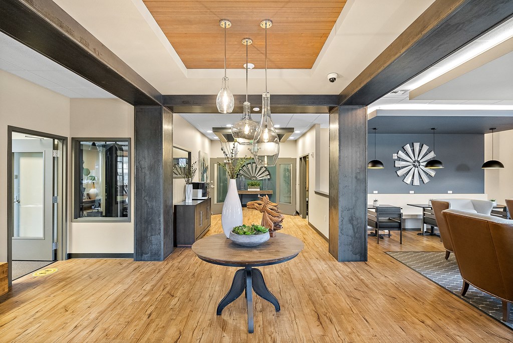 a living room with a wooden floor and a table with a vase on it
