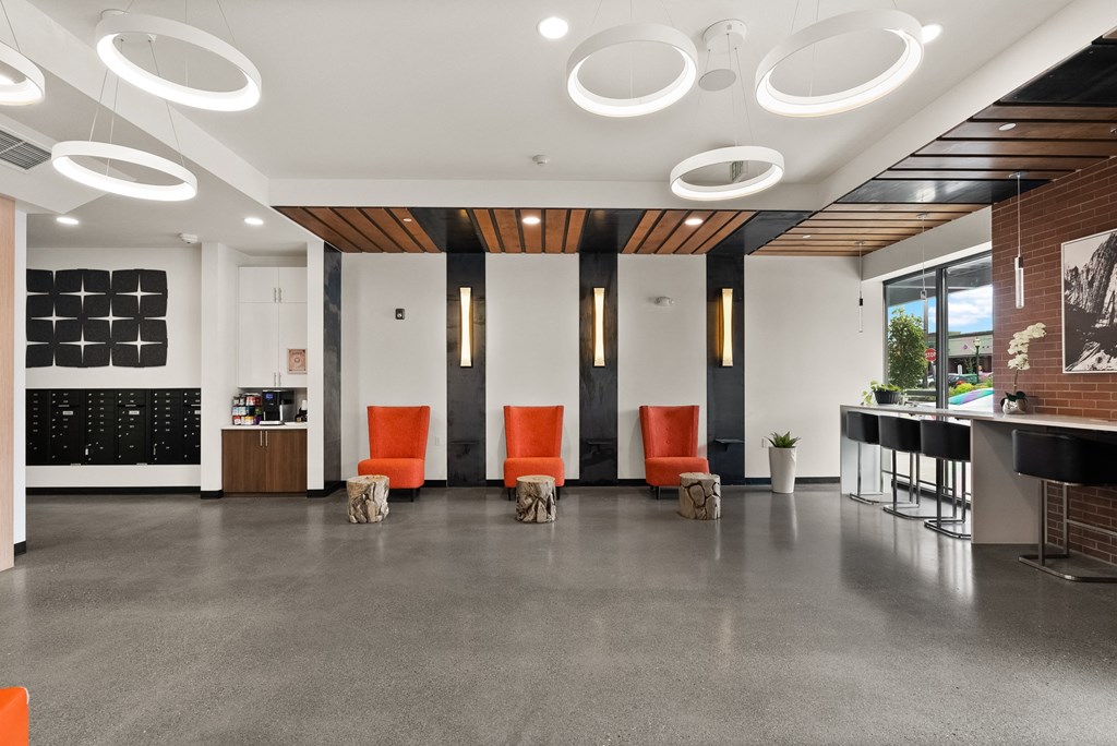 a large lobby with orange chairs and a bar and white walls