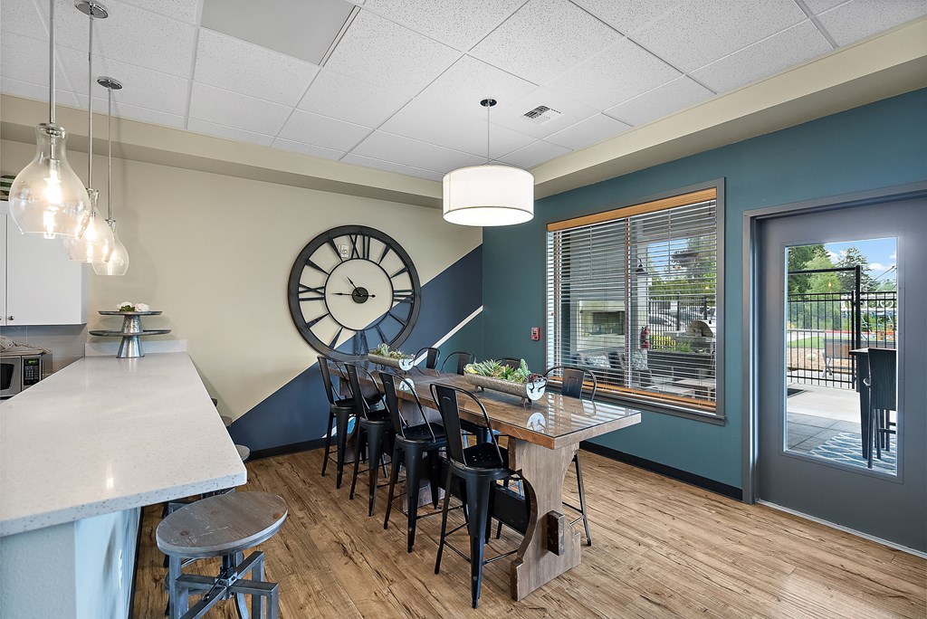our tasting room has a large clock on the wall and a long table with chairs