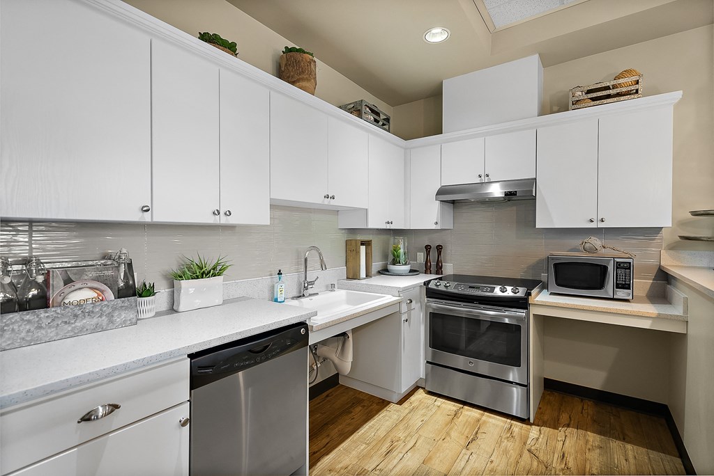 a kitchen with white cabinets and stainless steel appliances