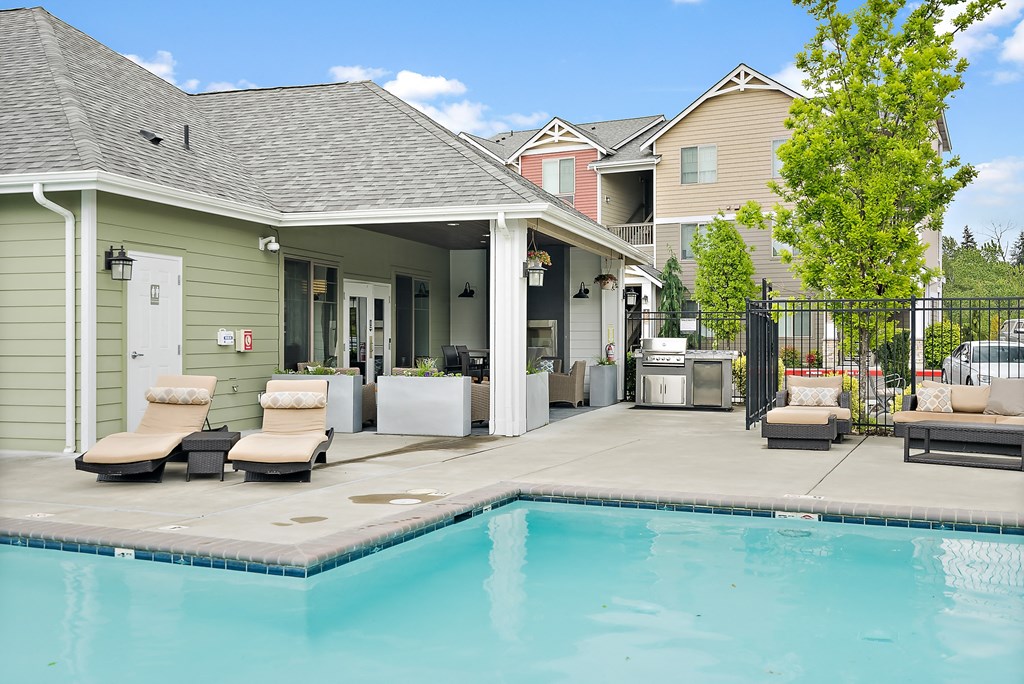 the pool and patio area of a house with a swimming pool
