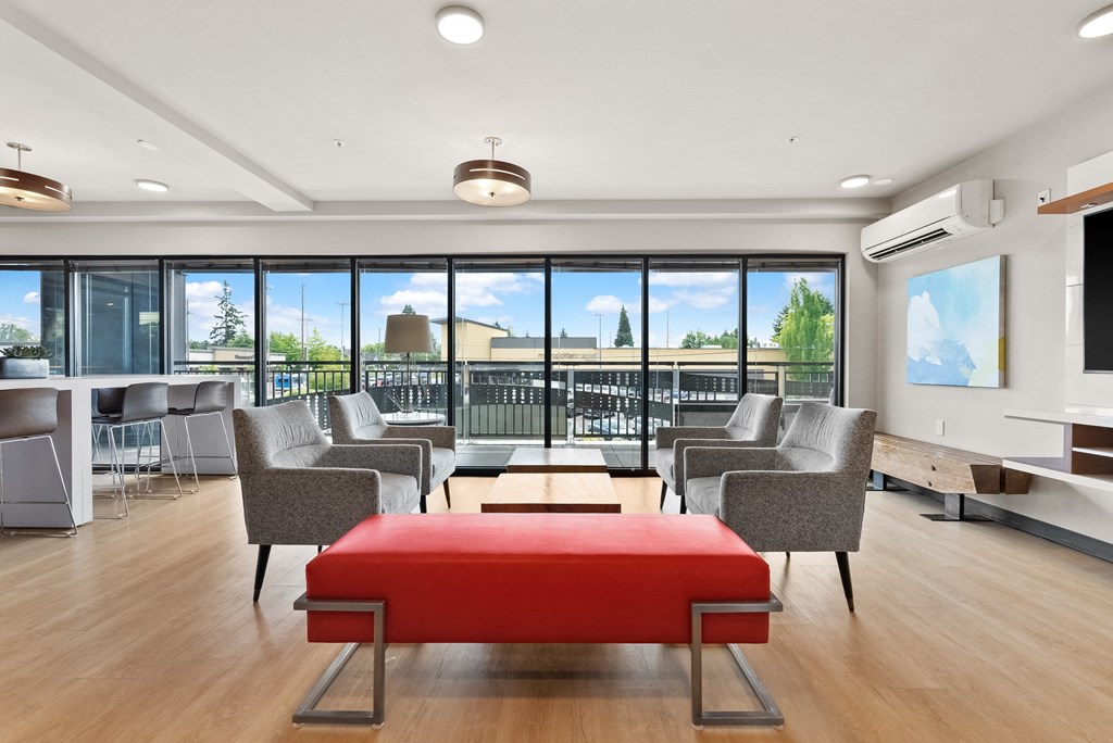 a conference room with couches and chairs and a red ottoman