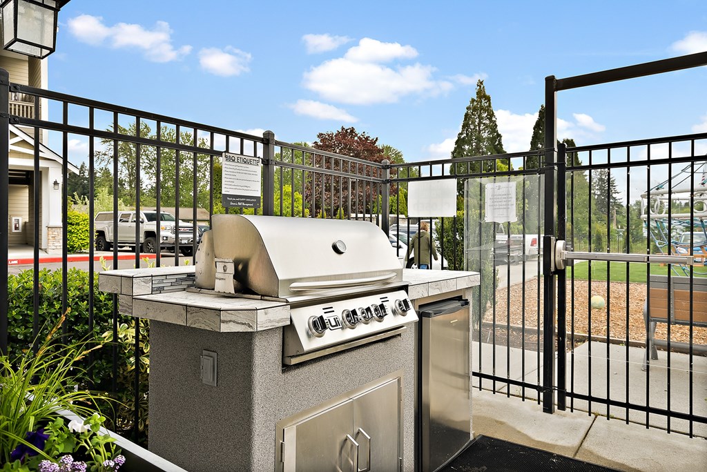 an outdoor grill area with a wrought iron fence