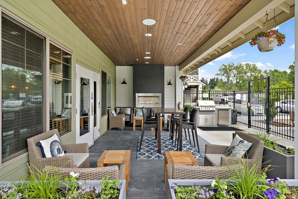 a porch with a table and chairs and a grill