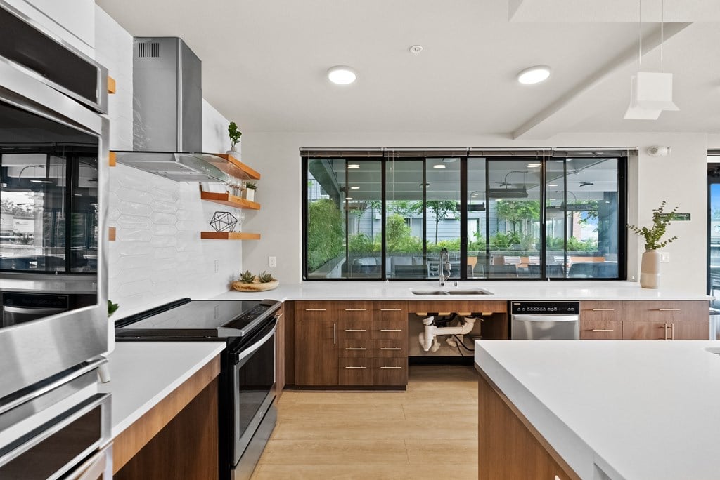 a kitchen with white counter tops and a large window