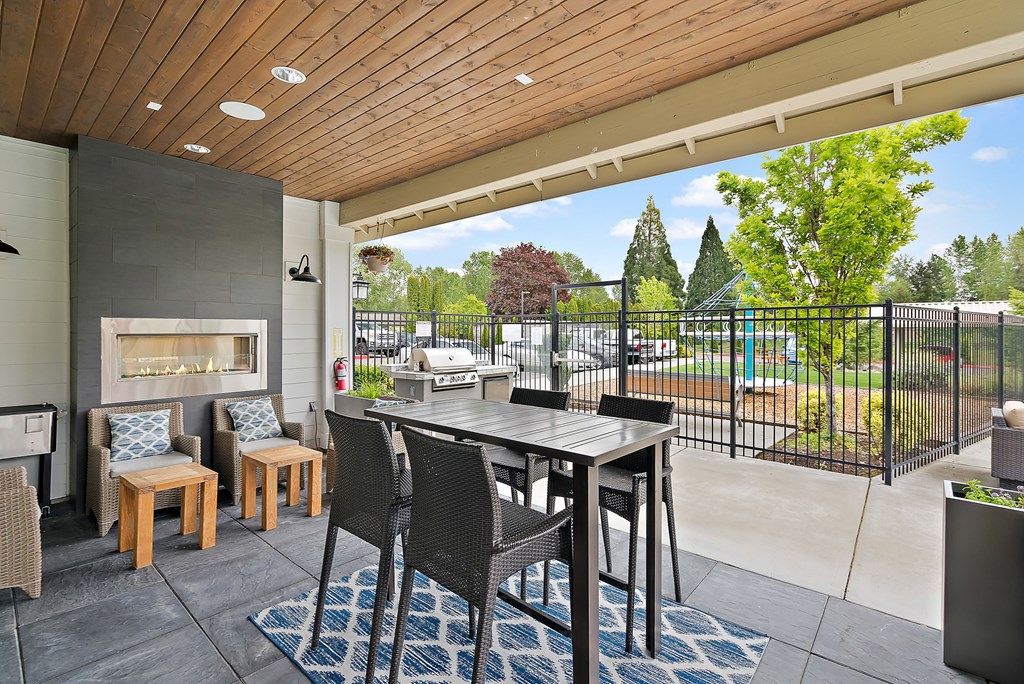 a patio with a table and chairs and a fireplace