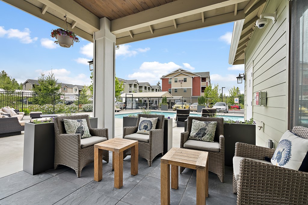 a patio with tables and chairs and a swimming pool