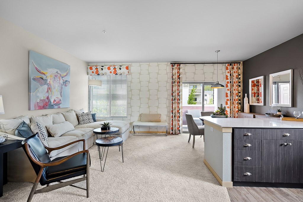 a living room with a white couch and a kitchen