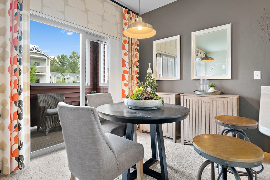 a living room with a table and chairs and a balcony