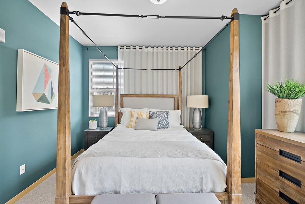 a bedroom with blue walls and a bed with a canopy