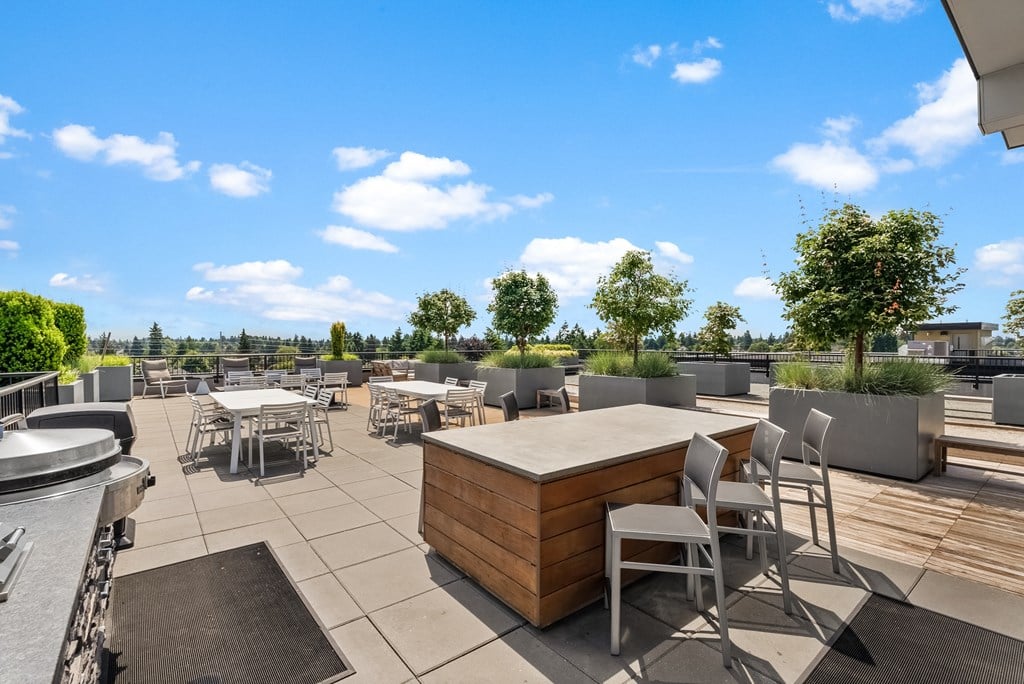a patio with tables and chairs and a hot tub on a roof
