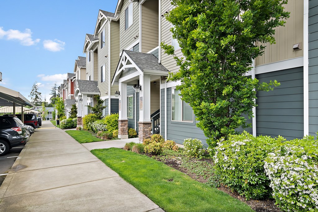a sidewalk in front of a row of houses