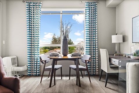 a dining room with blue and white curtains and a table with chairs